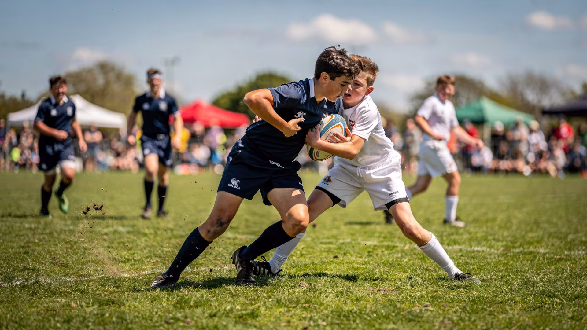 Youth rugby player breaking through a tackle during a rugby festival match