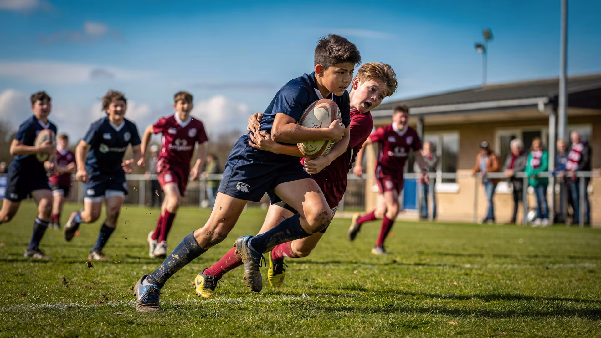 Youth rugby player breaking through a tackle in an away match