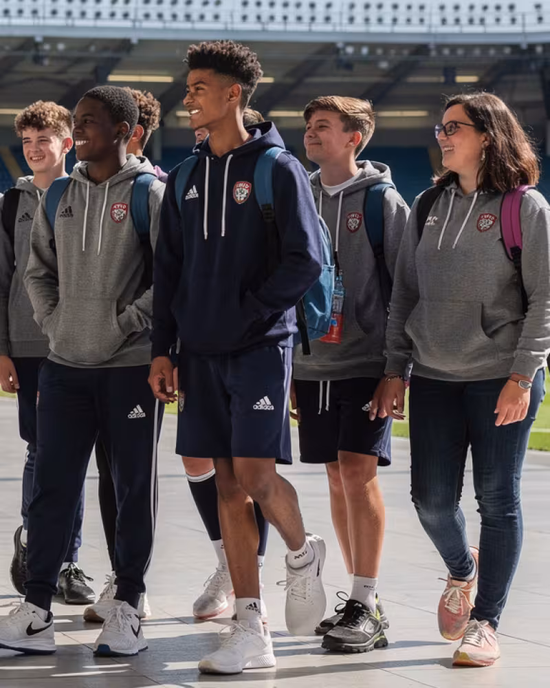 Youth rugby team taking a guided stadium venue tour