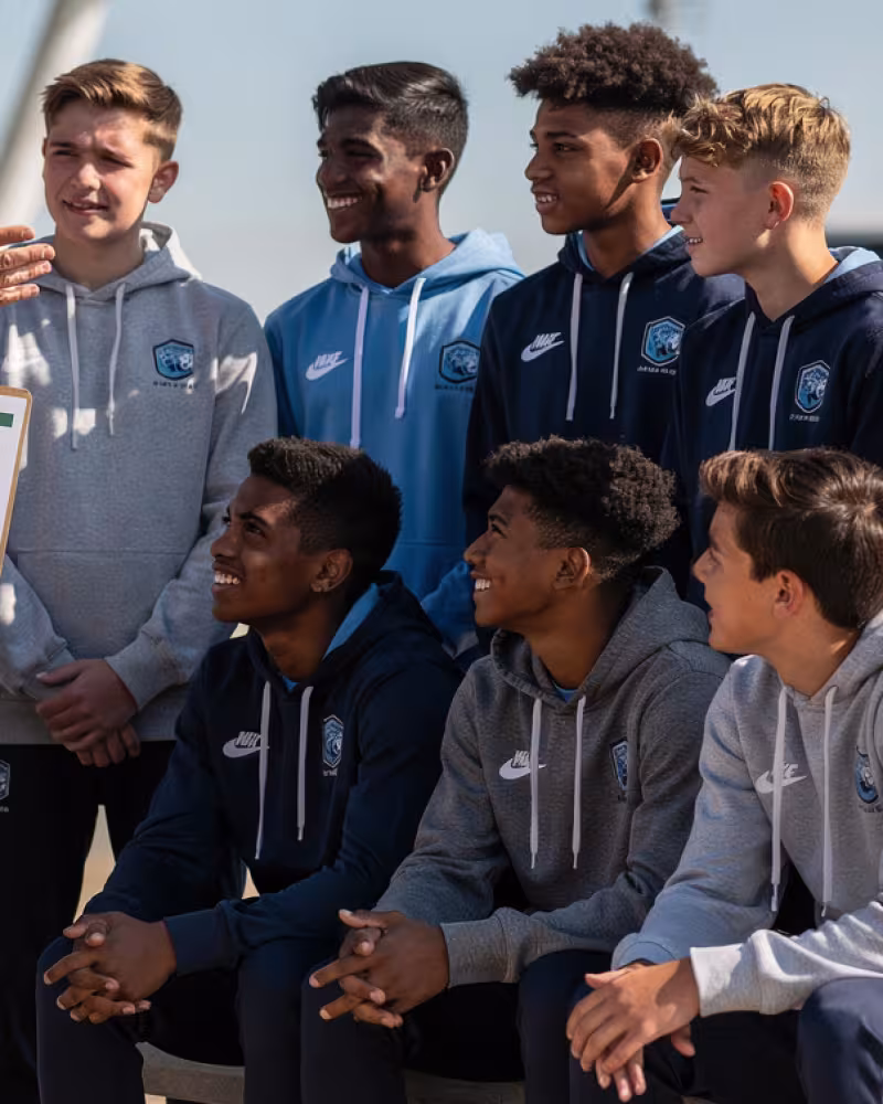 Youth rugby team reviewing a tour itinerary with their coach