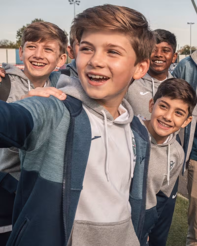 Youth rugby team taking a selfie with a professional player