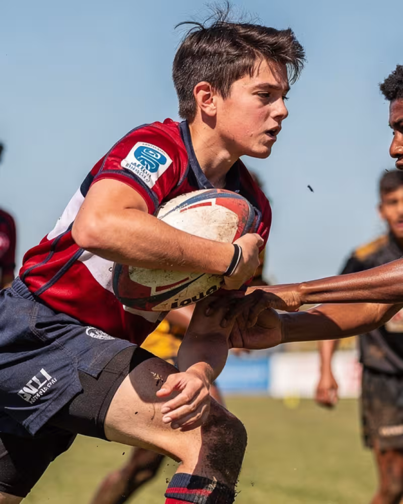 Teenage boys competing for the ball during a rugby match