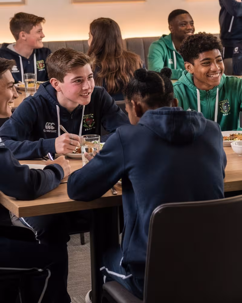 Youth rugby teams sharing post-match hospitality in a clubhouse