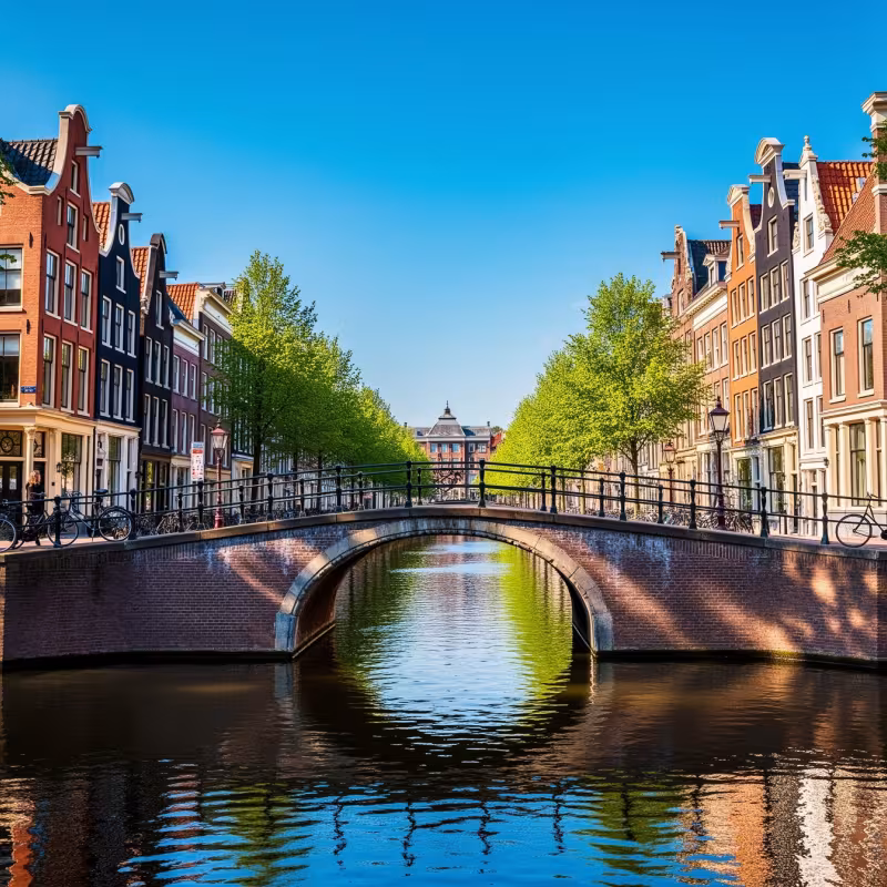 A canal bridge in Amsterdam, Netherlands, under bright blue sky
